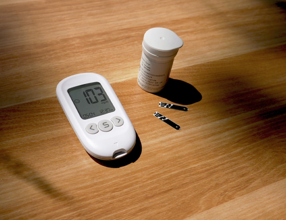 un termómetro, pastillas y una botella sobre una mesa