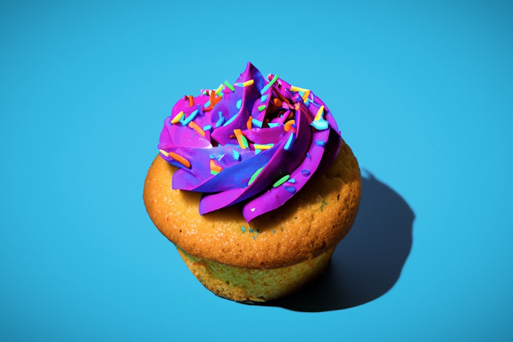 ein Cupcake mit lila Zuckerguss und Streuseln