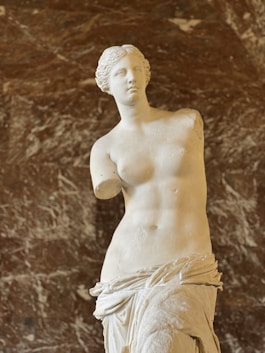 a marble statue of a woman in front of a marble wall