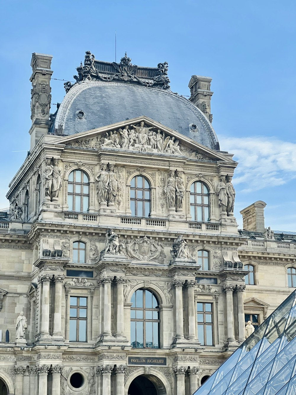 a large building with many windows and statues on top of it