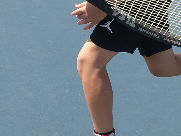Close-up of a vibrant women's tennis dress in motion on a sunny court.