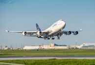 An airplane taking off with cargo containers visible in the foreground.