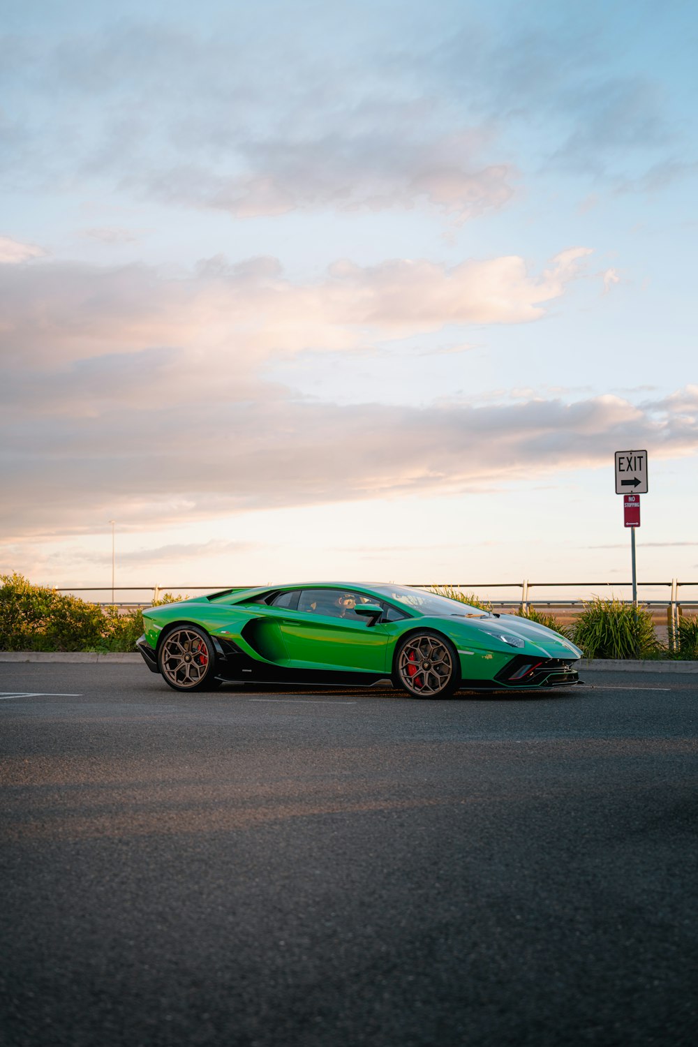 a green sports car parked on the side of the road