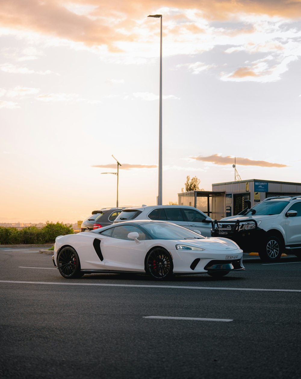 a white sports car parked in a parking lot