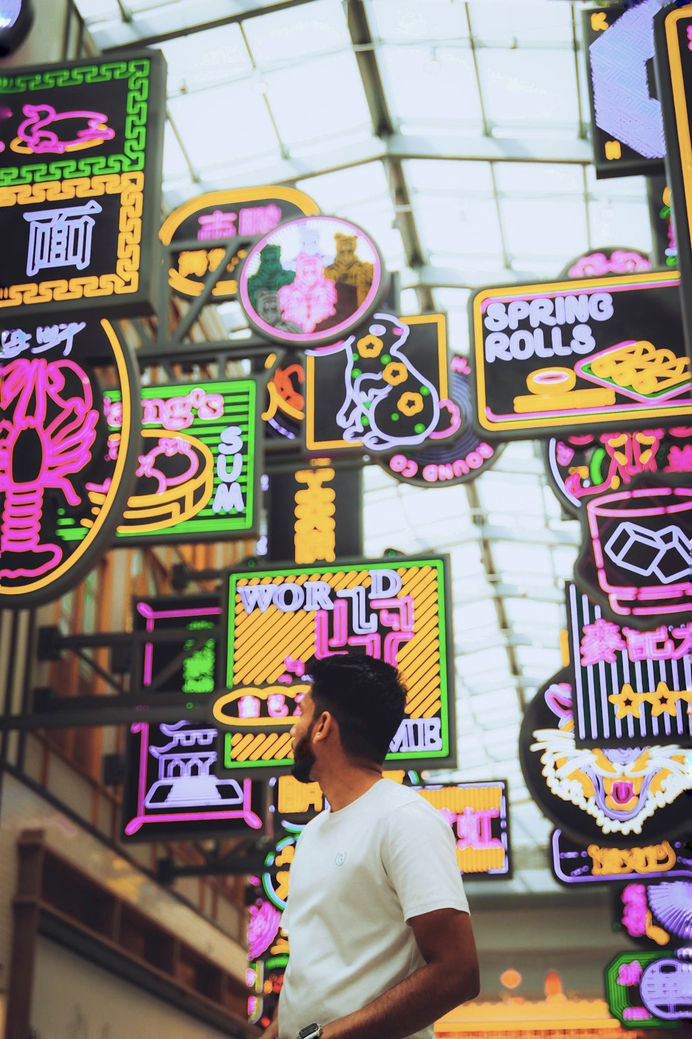 a man standing in front of a display of neon signs