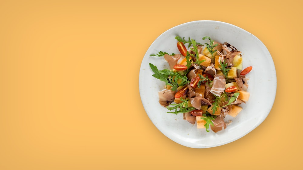 a plate of food on a yellow background