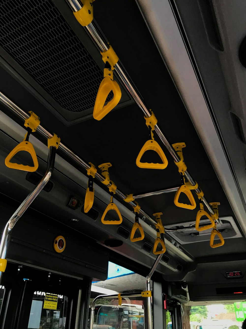 the interior of a public transit bus with yellow handrails