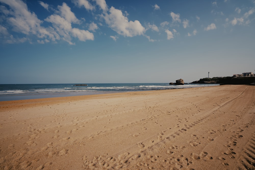 a sandy beach with footprints in the sand