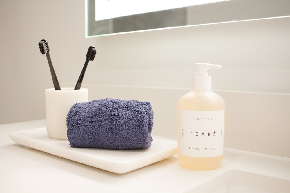 un comptoir de salle de bain avec savon, brosse à dents et distributeur de savon