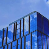 A sleek modern building with large glass windows reflecting the sky.