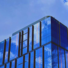 Modern commercial building with glass facade reflecting the sky.