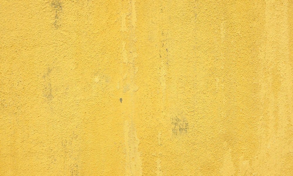 a close up of a yellow painted wall