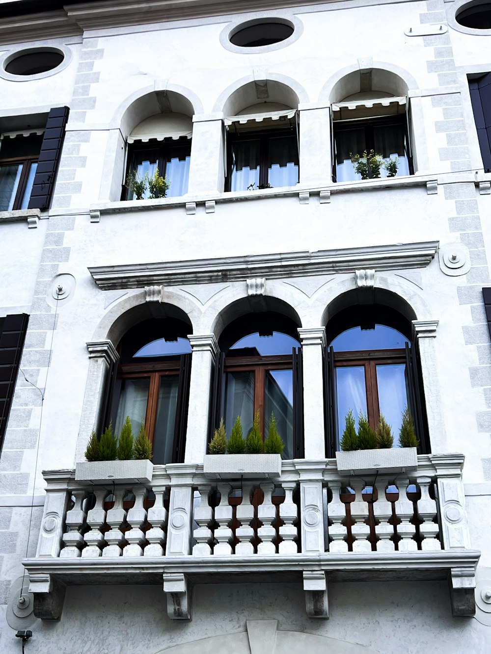 a tall white building with windows and balconies