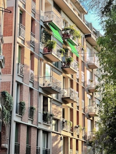 Charming vintage apartment with hardwood floors and a sunny balcony overlooking trees.