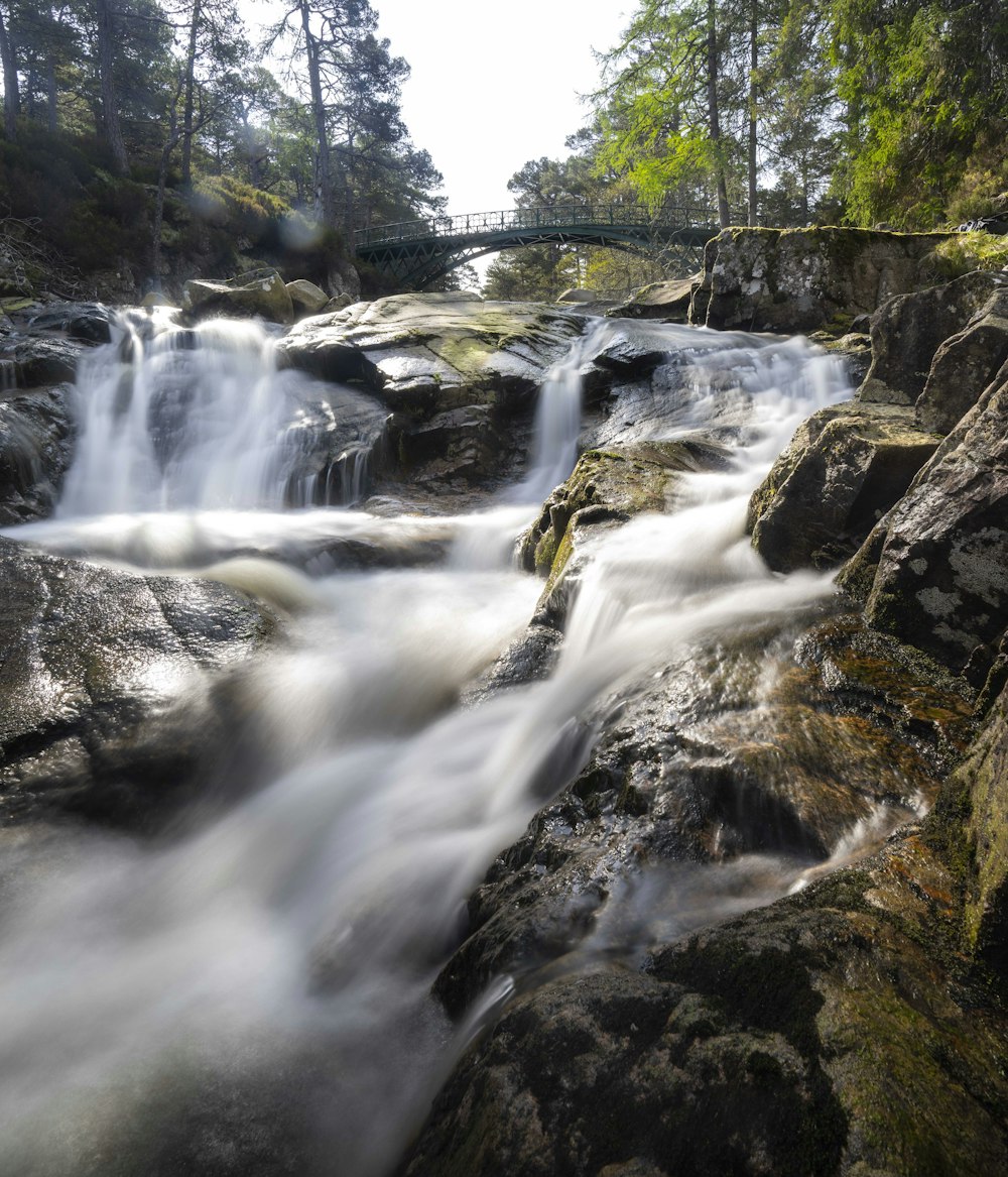 a waterfall flowing over rocks into a river