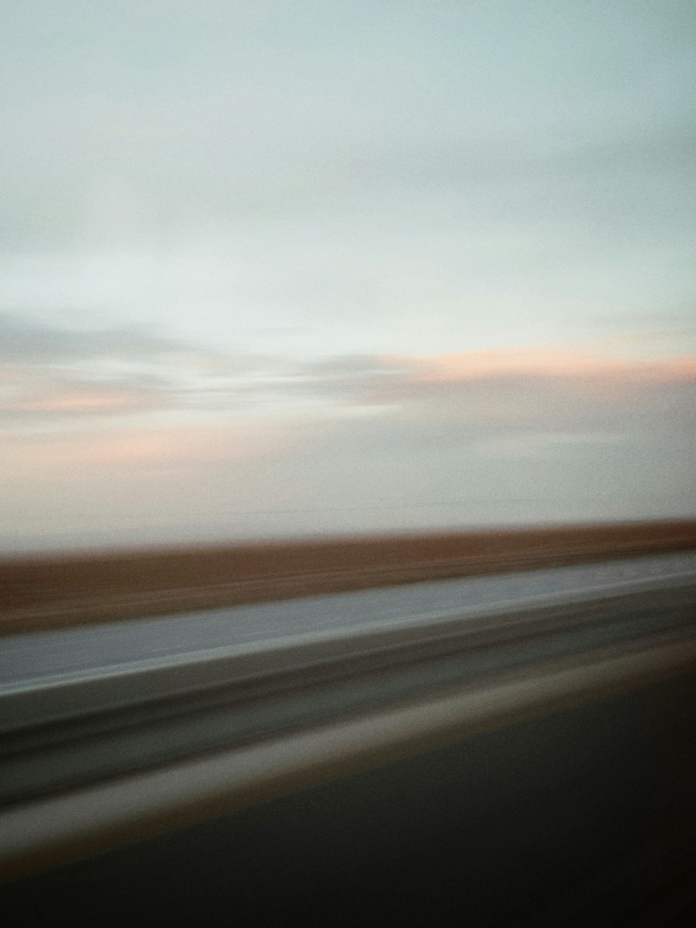 a blurry photo of a highway with a sky in the background