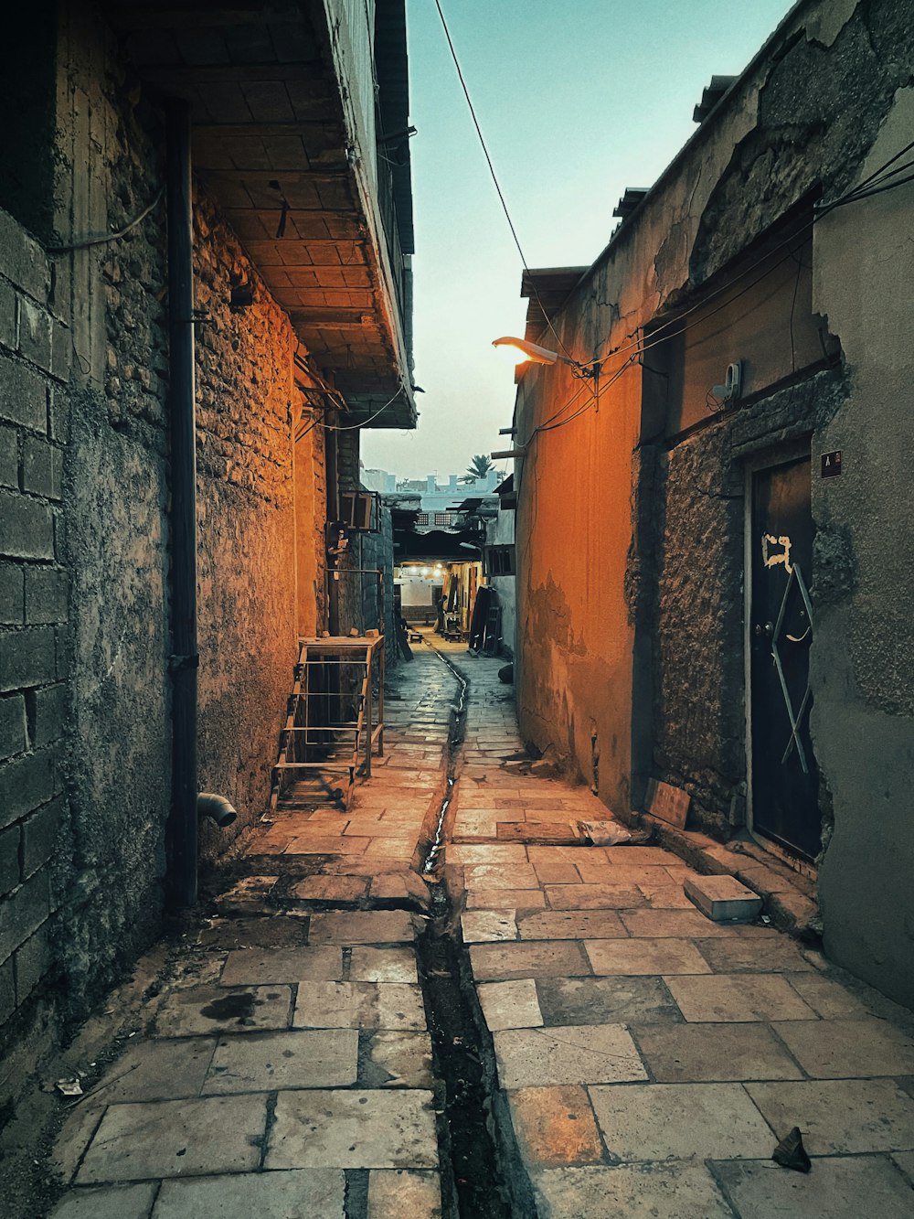 an alley way with a brick sidewalk and a door