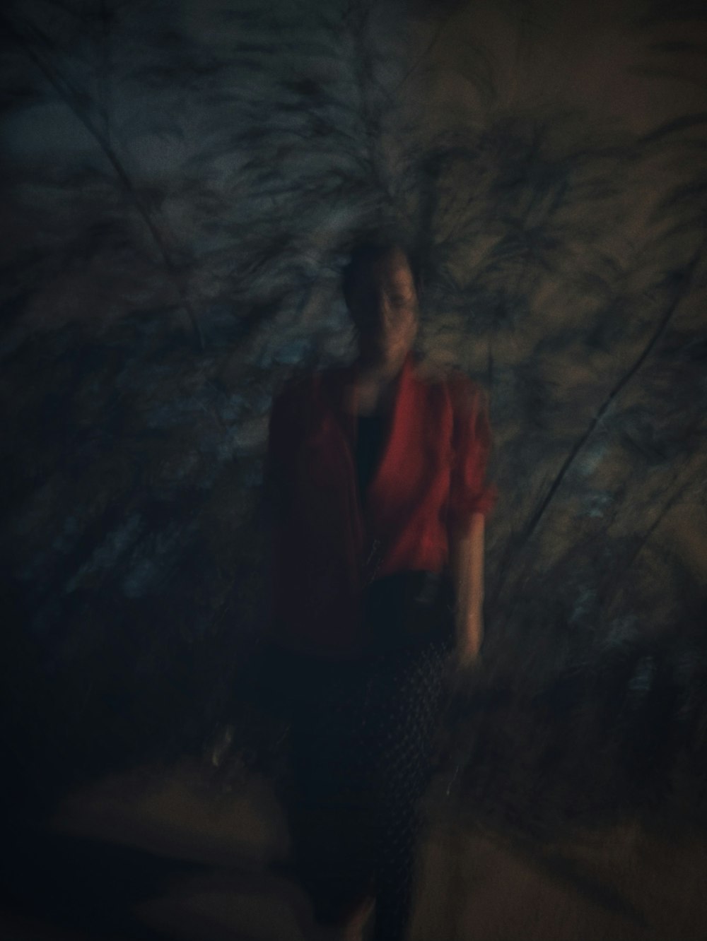 a woman standing in front of a tree in the dark