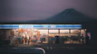 a store front with a mountain in the background
