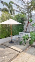 An outdoor patio set up with modern furniture and plants.