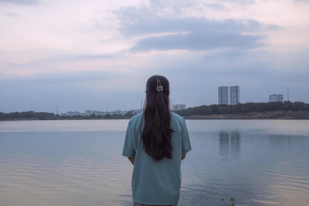 a woman standing in the water looking at the sky