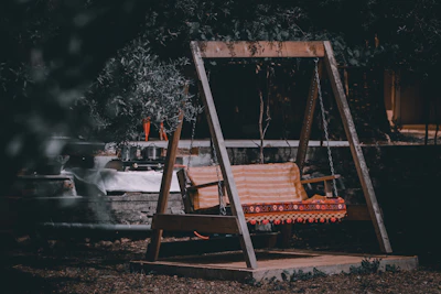 A cozy garden swing set with soft cushions, perfect for relaxing adults and playful kids.