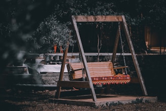 A stylish hanging porch swing adorned with cushions.