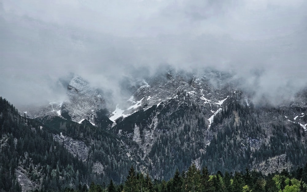 Eine Bergkette, die mit Schnee und Wolken bedeckt ist
