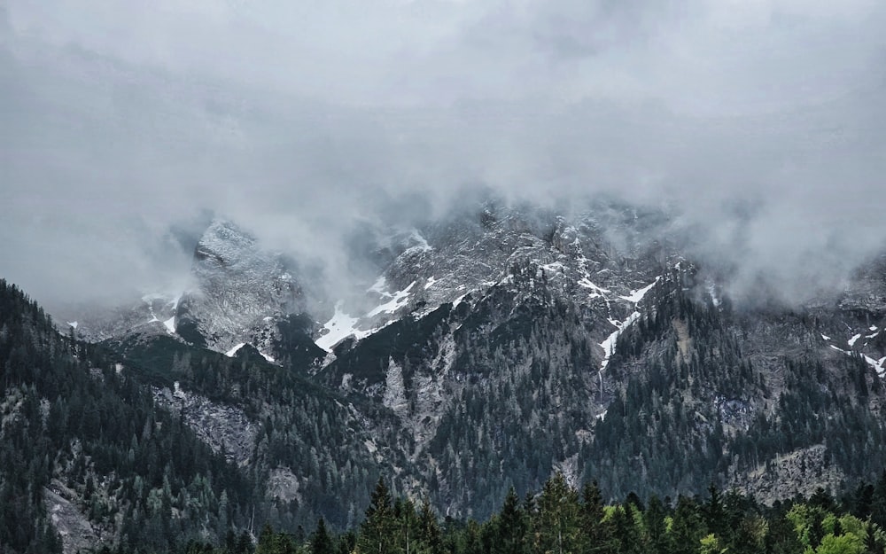 a mountain range covered in snow and clouds