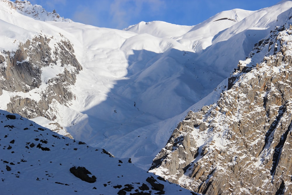 a snow covered mountain with a bird flying over it