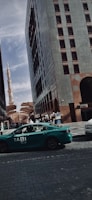 A scenic view of a taxi driving through Jeddah city streets at sunset.
