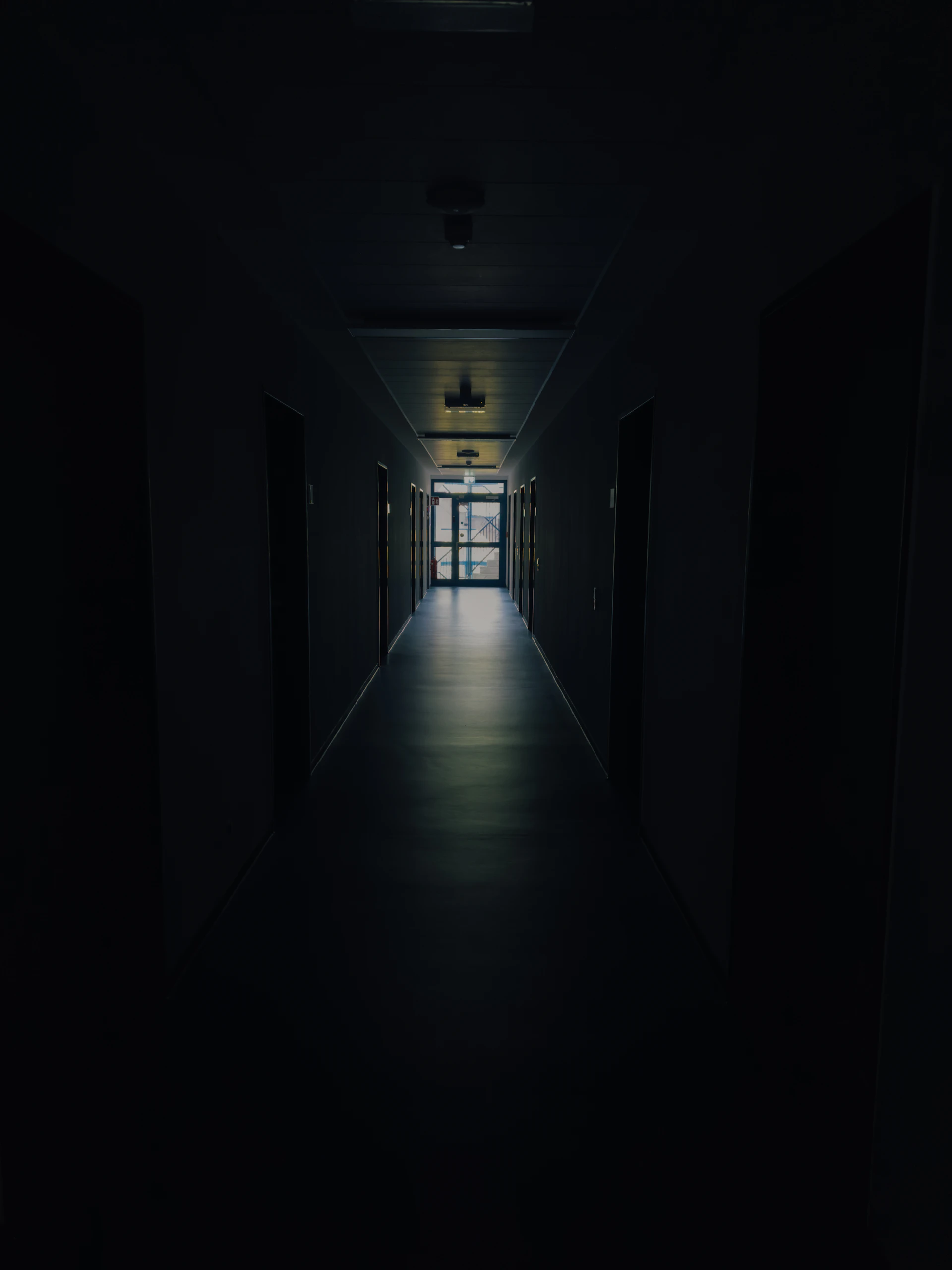 A dark corridor with light at the far end