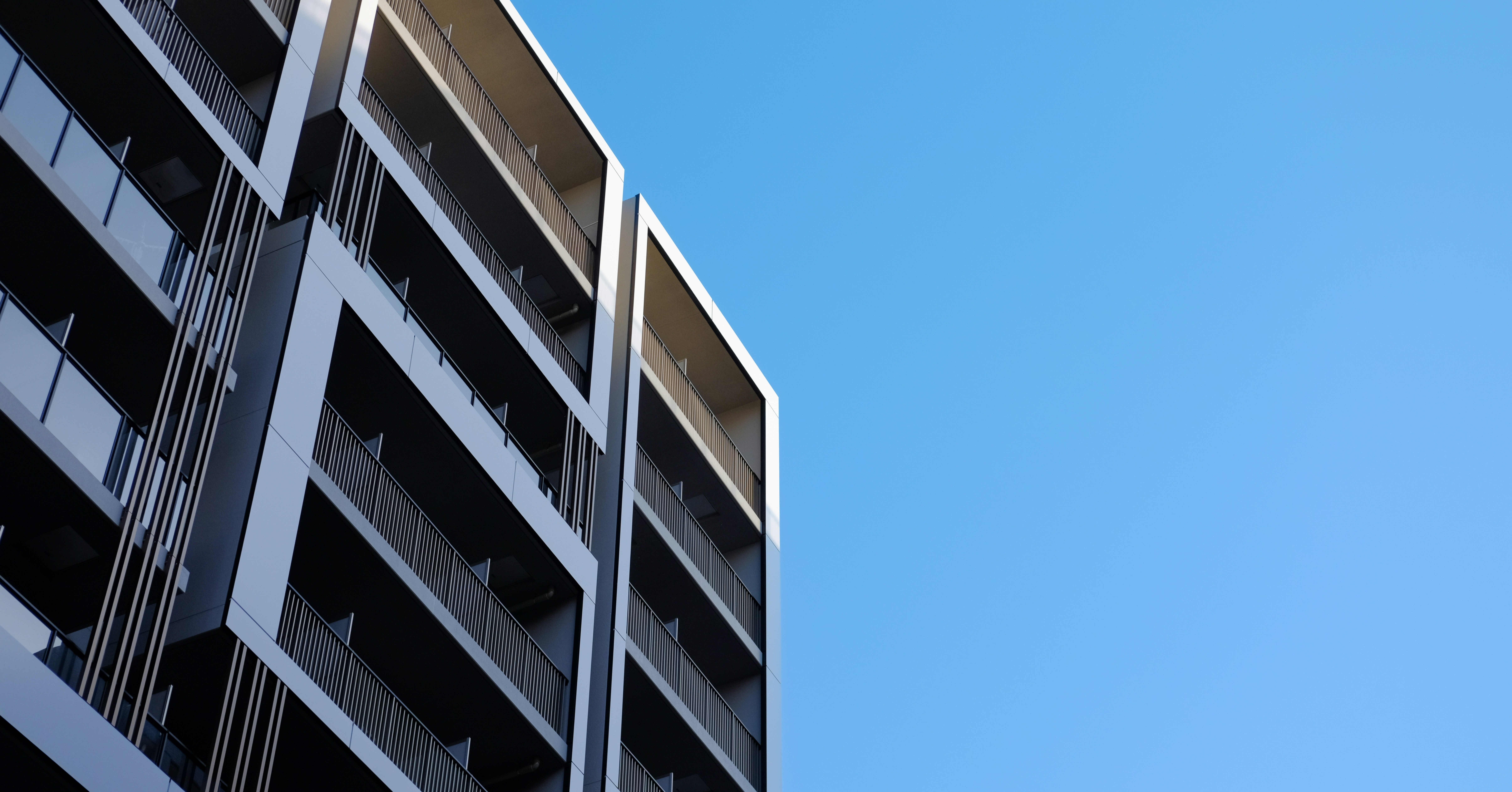 a tall building with balconies against a blue sky
