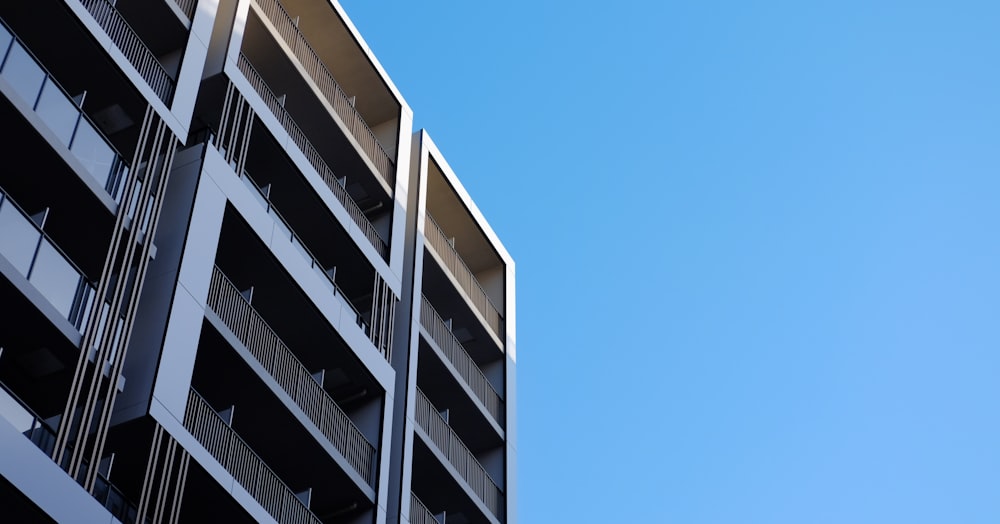 a tall building with balconies against a blue sky