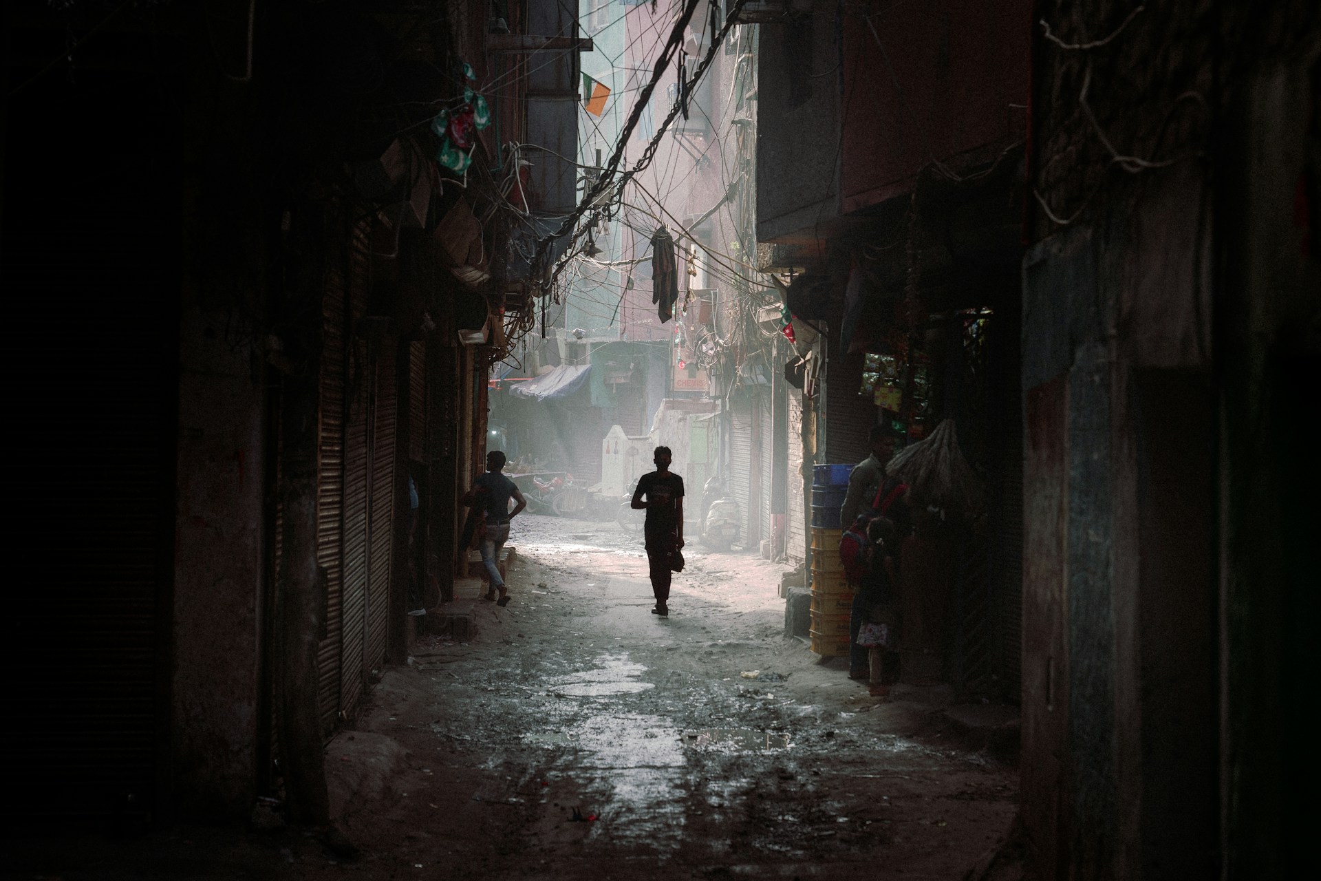 a man is walking down a narrow alley way