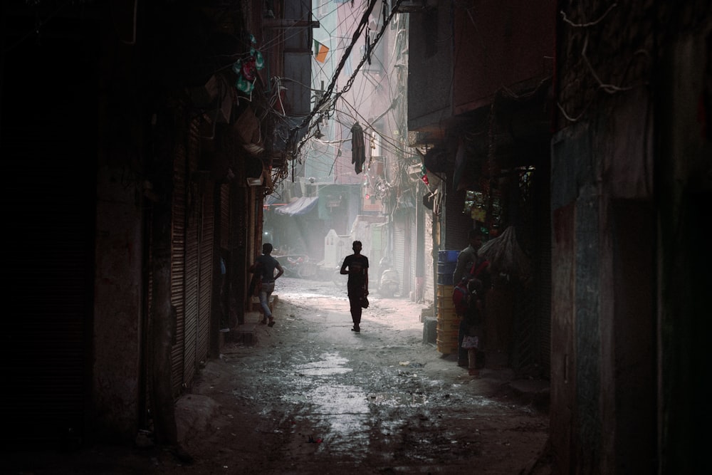 a man is walking down a narrow alley way