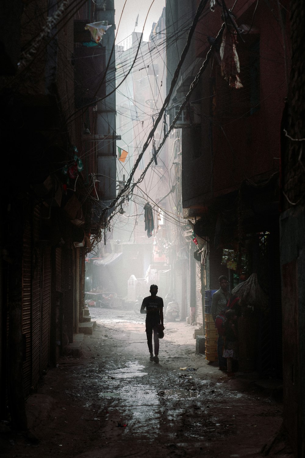 a man walking down a street next to tall buildings