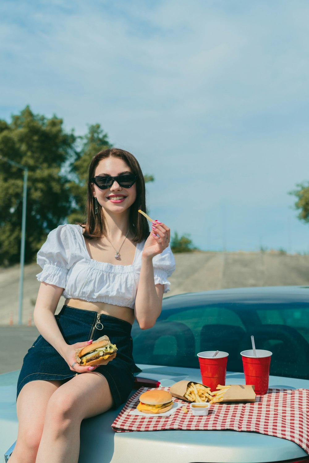 a woman sitting on the hood of a car