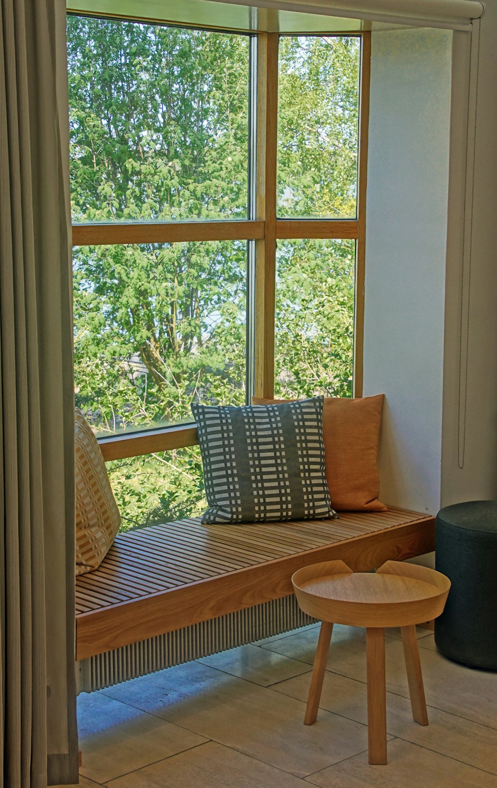 a wooden bench sitting in front of a window