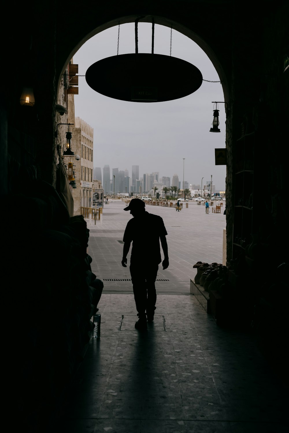 a man walking out of a tunnel into a parking lot