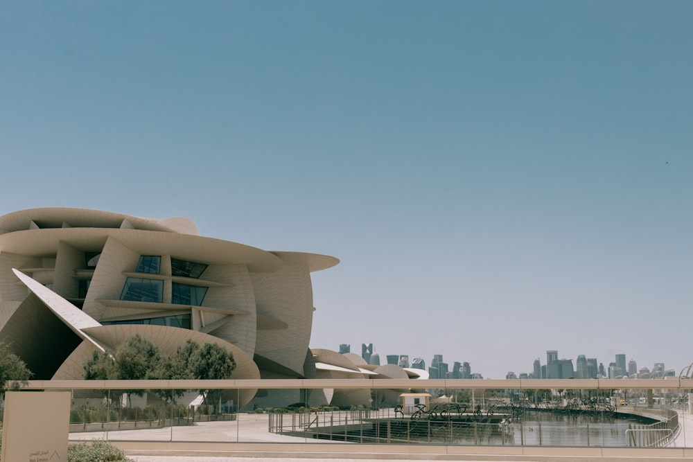 Un gran edificio con un techo curvo junto a un cuerpo de agua