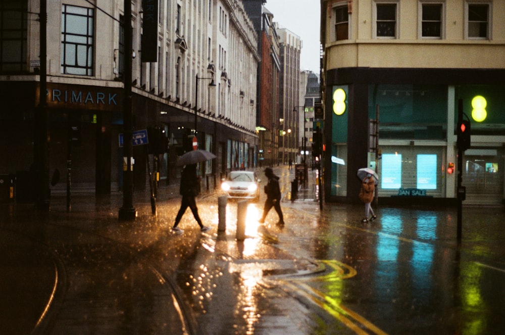 Eine Gruppe von Menschen, die mit Regenschirmen über eine Straße gehen