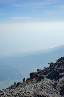 A group hiking up a scenic trail with mountains in the background on a clear day.