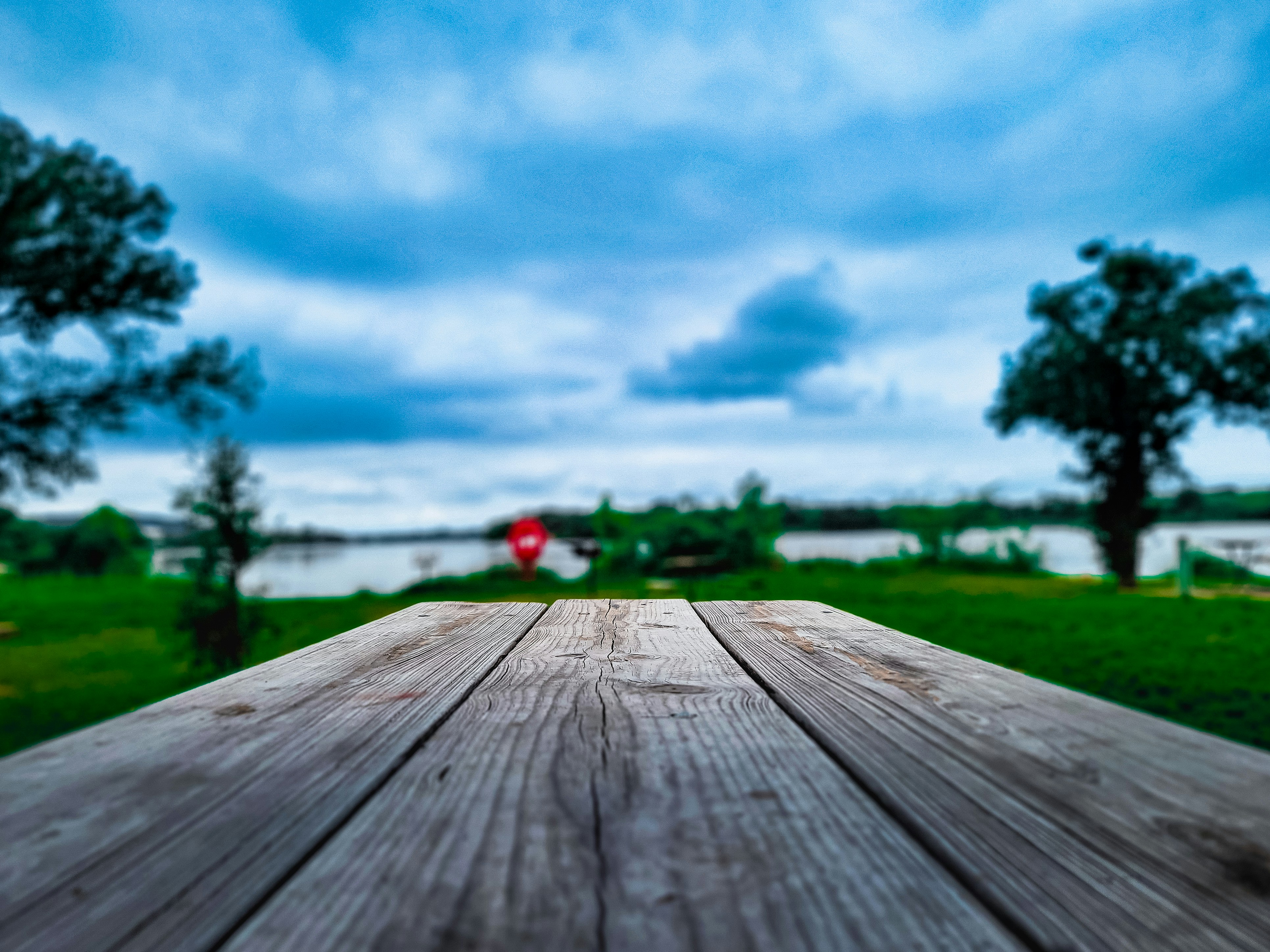 a wooden table with a view of a lake