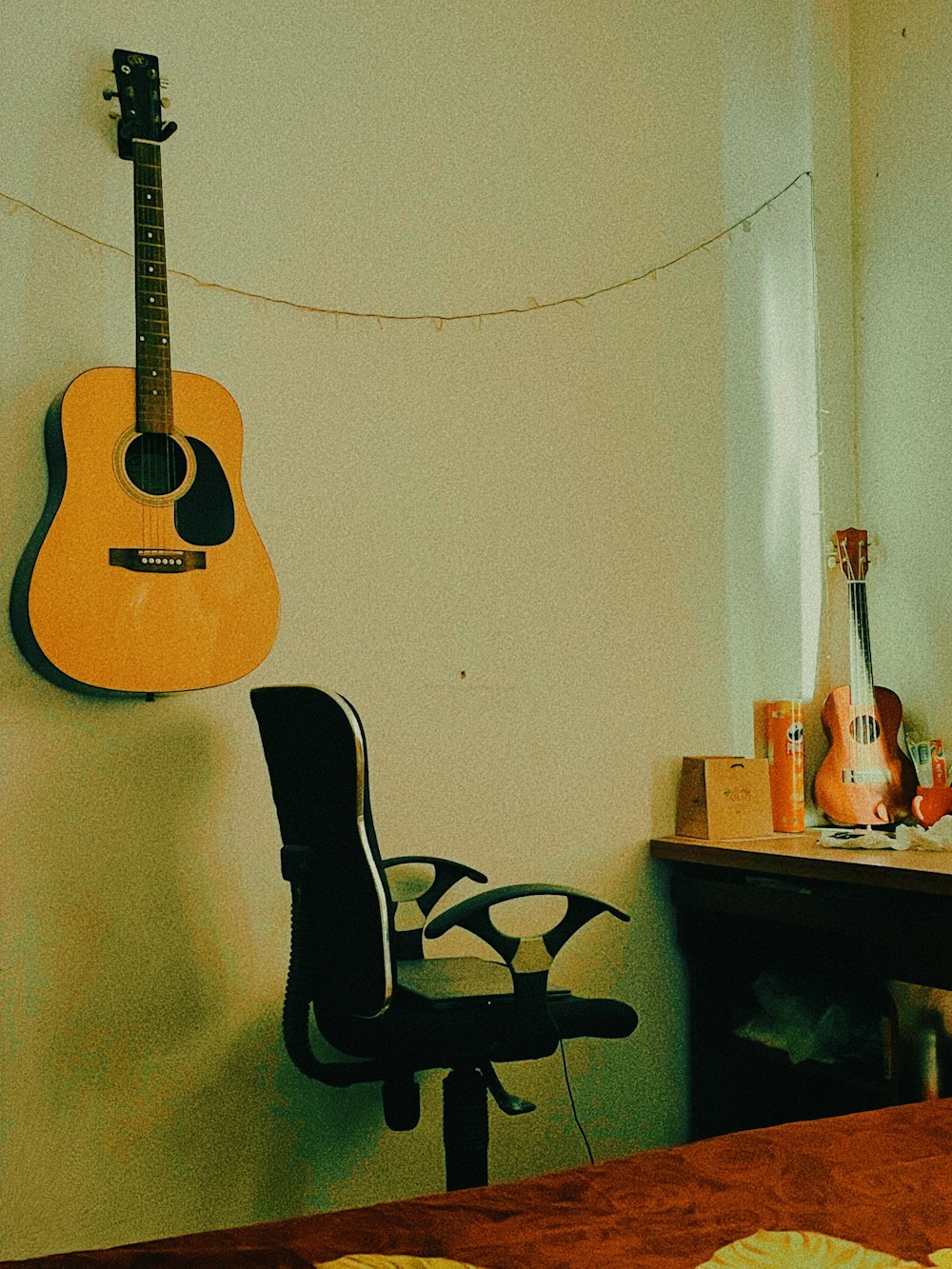 a guitar hanging on a wall next to a chair