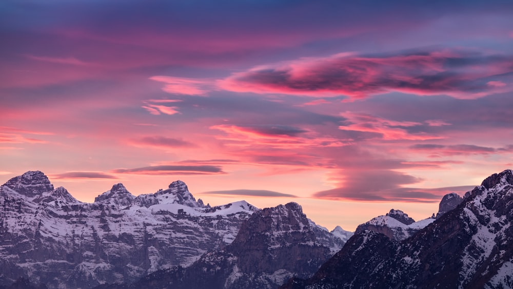 a pink and blue sky over a mountain range