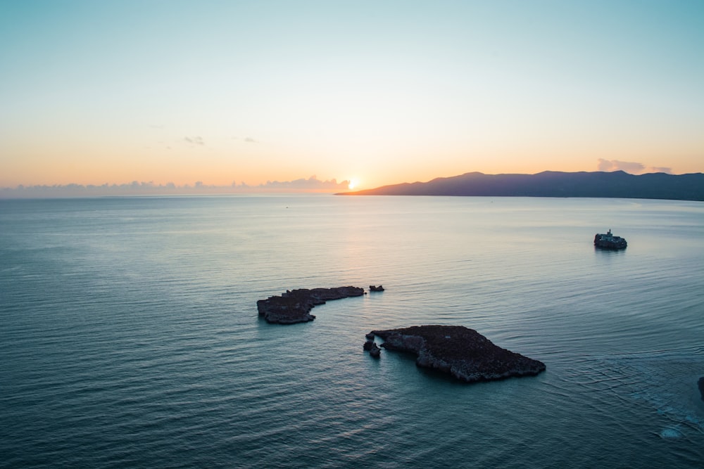 a large body of water with a boat in the distance