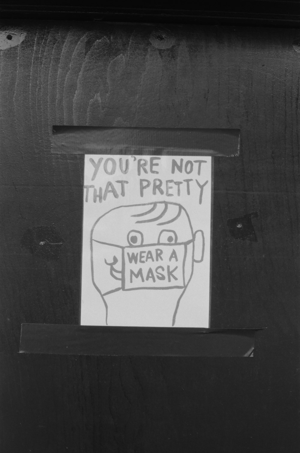 a sign on a door that says you're not that pretty wear a mask