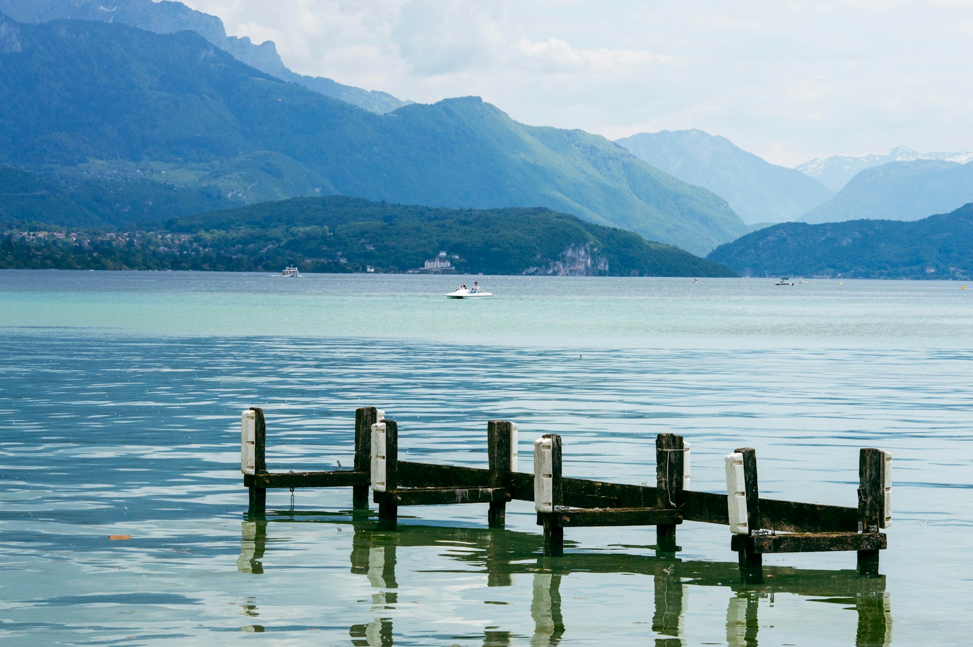 a dock in the middle of a lake with mountains in the background