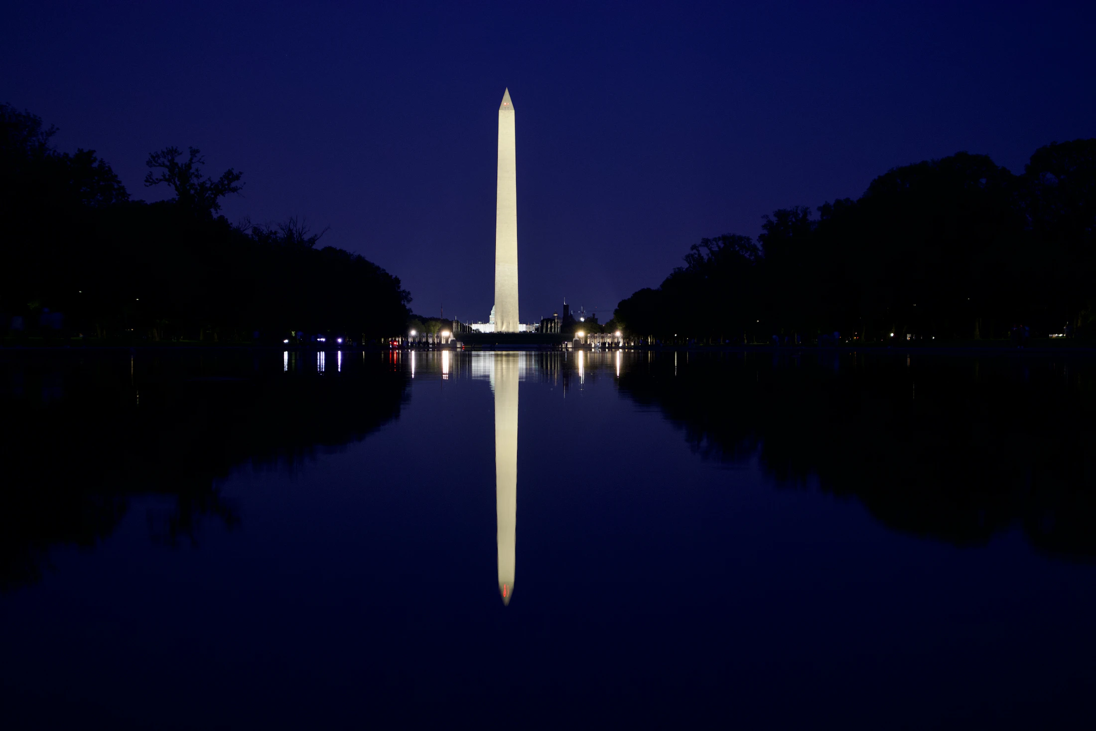 The Washington Monument reflected in water at night